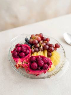 Dragon fruit shells filled with fruit balls, grapes and pineapple