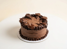 Decadent chocolate cake with 55% and 70% ganache layered between chocolate sponge, finished with piped chocolate rosettes