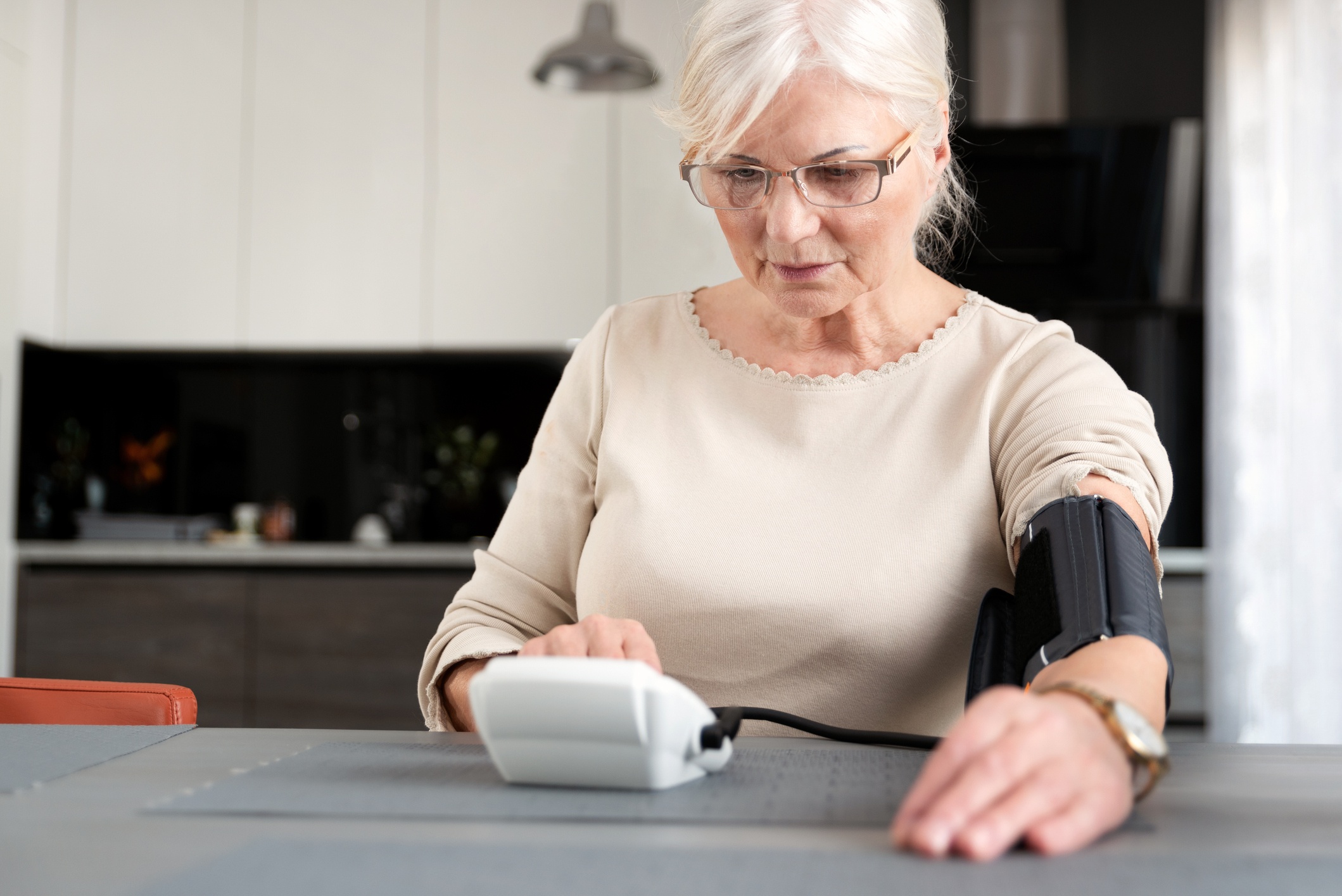 Woman 60 and up reading her blood pressure