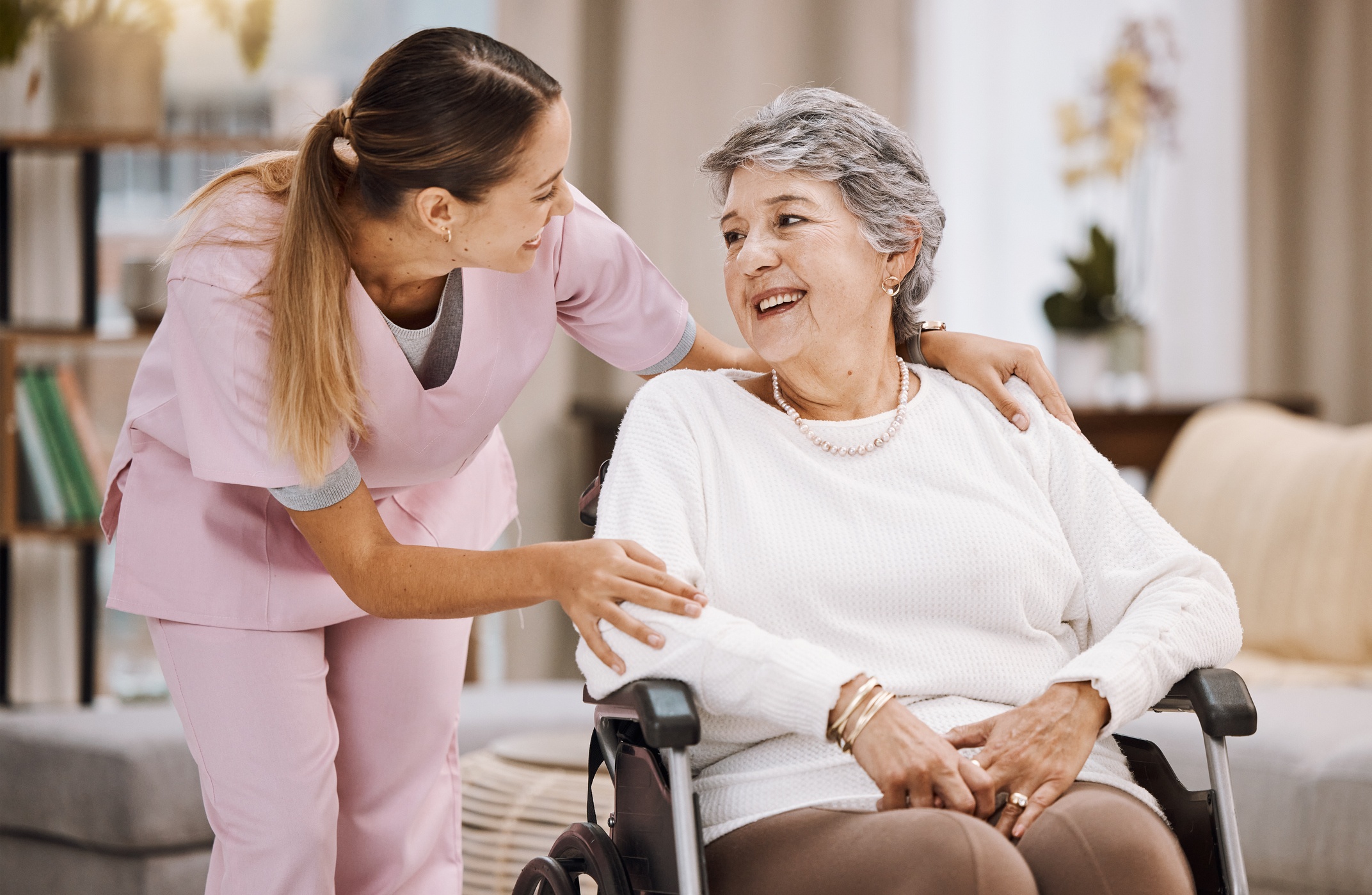 Nurse helping women 60+ in wheelchair