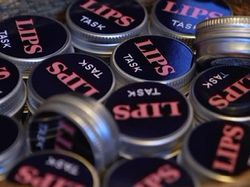 LIPS TASK logo på en samling runde bokser leppepomader.