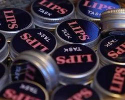 LIPS TASK logo på en samling runde bokser leppepomader.