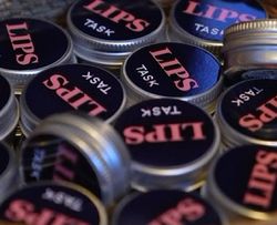 LIPS TASK logo på en samling runde bokser leppepomader.