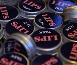 LIPS TASK logo på en samling runde bokser leppepomader.
