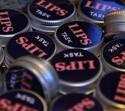 LIPS TASK logo på en samling runde bokser leppepomader.