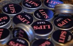 LIPS TASK logo på en samling runde bokser leppepomader.
