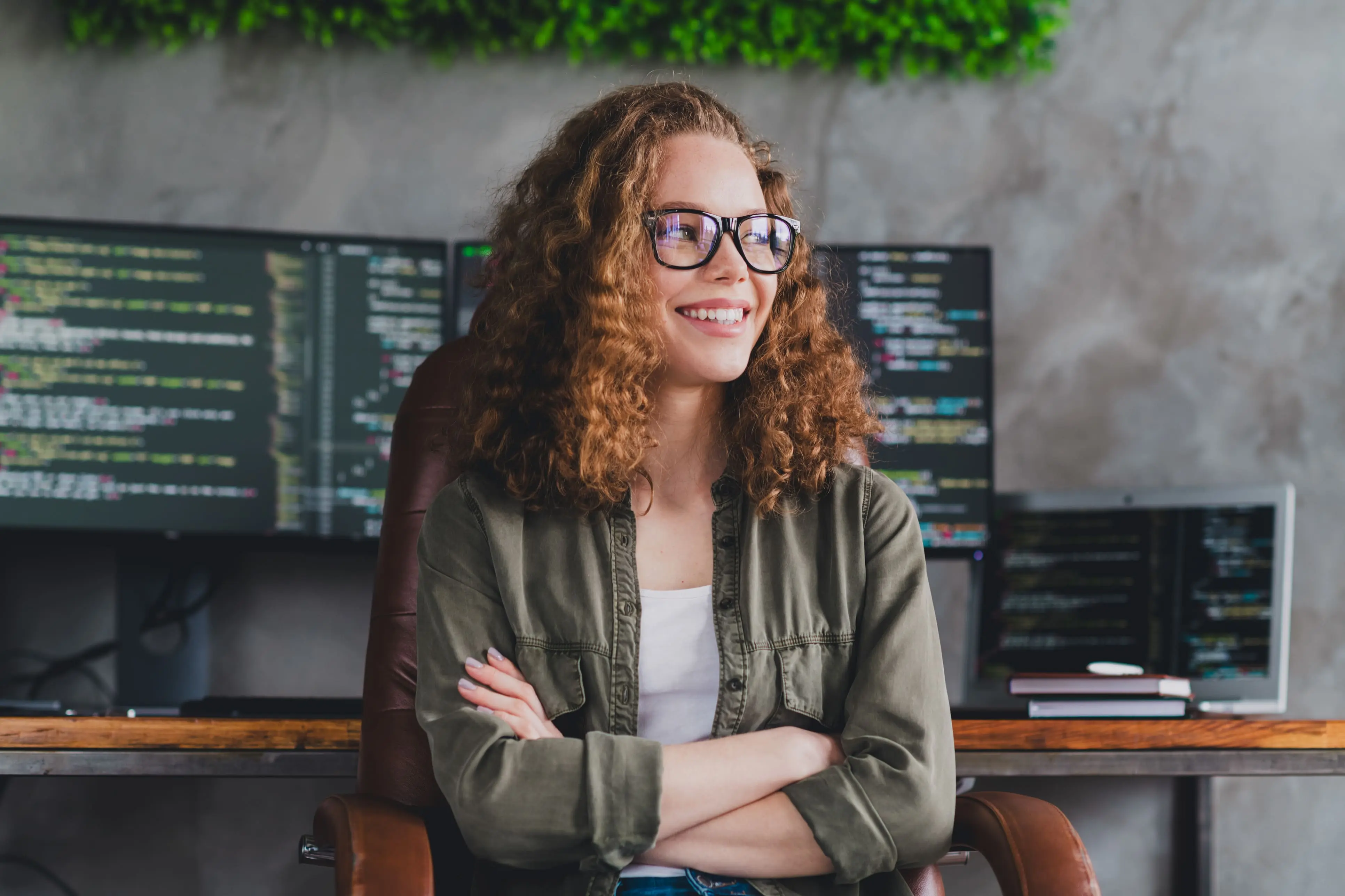 Jeune femme avec chemise verte et fond d'ordinateurs