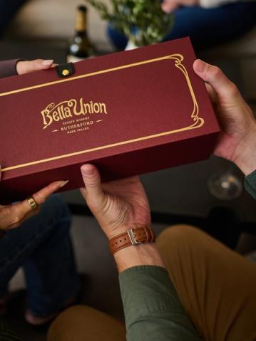 A luxury Bella Union Winery gift box being handed from one person to another, making it perfect for corporate wine gifts and holiday wine gifts.