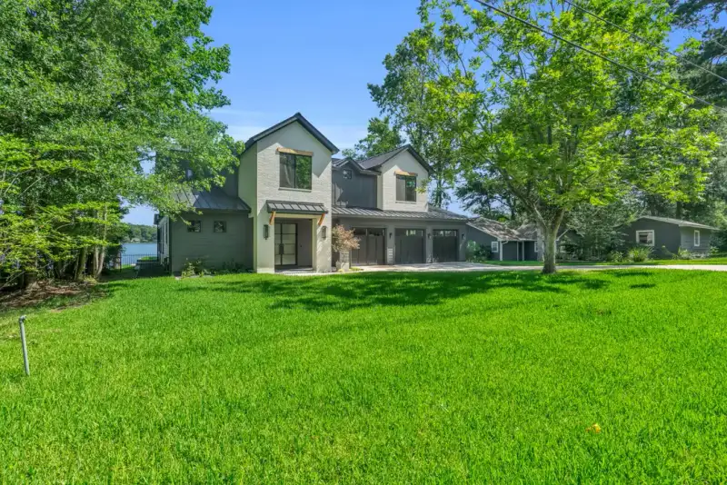 Side view of the Southshore home across a green lawn, with mature trees on both sides.