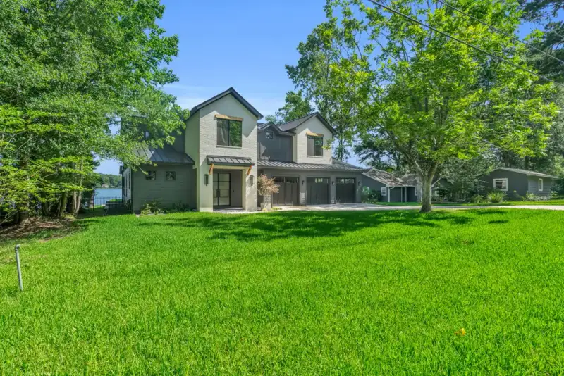 Side view of the Southshore home across a green lawn, with mature trees on both sides.
