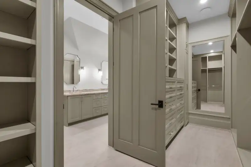 Walk-in closet with drawer units, open cabinetry, and a mirror on the far door.