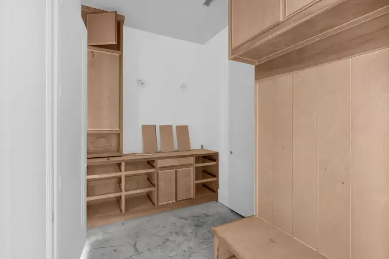 Mudroom with wood cabinets, open shelves, and a built-in bench along the right wall.