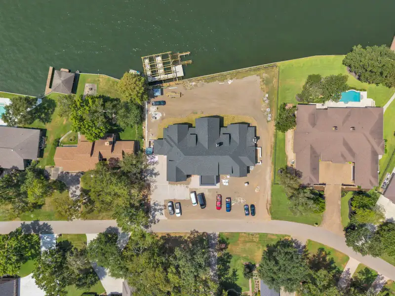 Overhead view of the Escondido home's gray roof and driveway, with neighboring homes and trees around it.