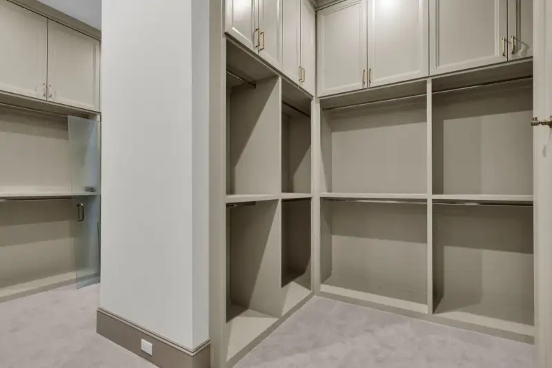 Closet with open shelving, hanging rods, and a frosted glass door at the left.