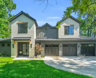 Front facade of the Southshore home with gray brick, metal roof accents, and garage doors.