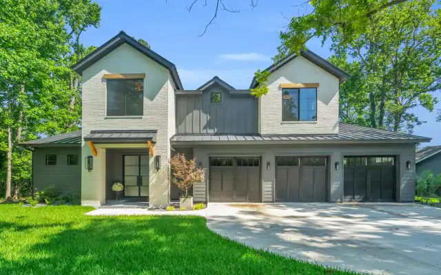 Front facade of the Southshore home with gray brick, metal roof accents, and garage doors.