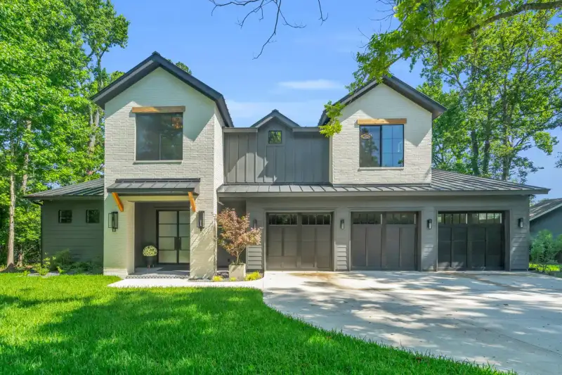 Front facade of the Southshore home with gray brick, metal roof accents, and garage doors.