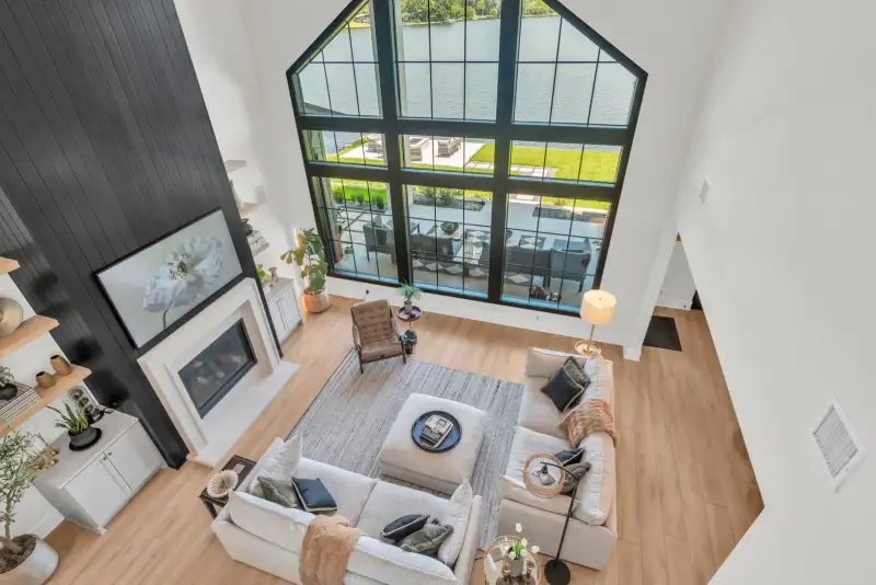 Living room viewed from above, with a gabled window, a dark shiplap fireplace wall, and a gray sectional.