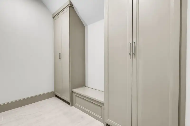 Mudroom with tall taupe cabinets and a built-in bench.