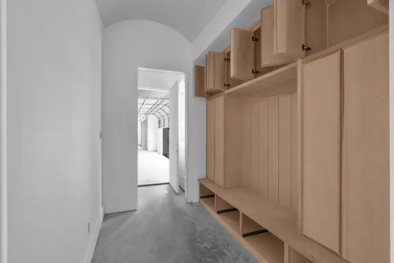 Mudroom with an arched doorway at the end and wood lockers with a built-in bench.