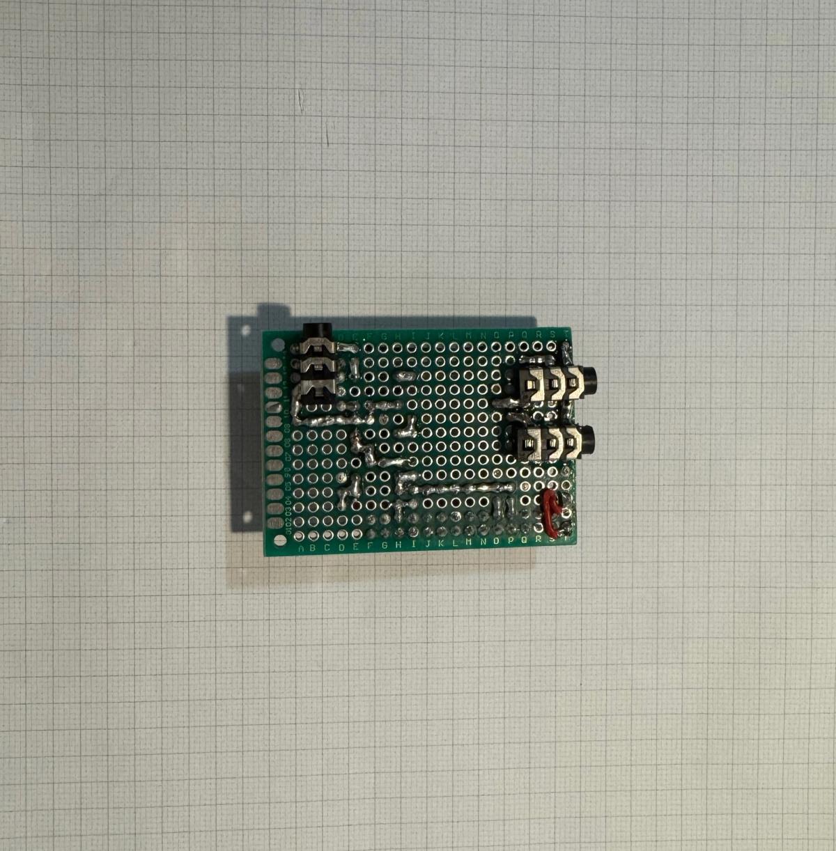 Solder side of the completed perfboard HAT showing hand-soldered connections, connecting wires and the pins of the audio sockets.
