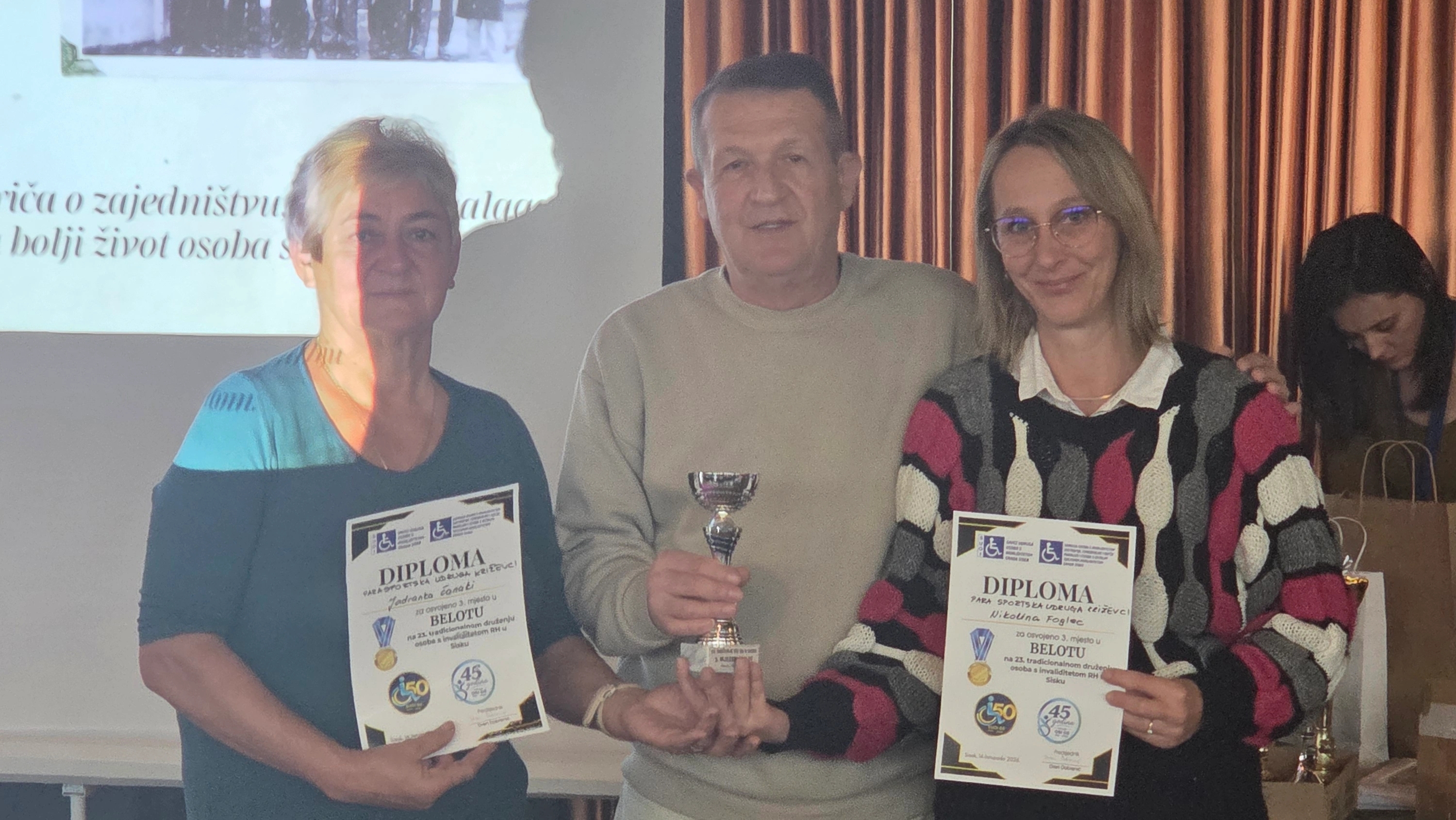Troje sudionika susreta u Sisku pozira s peharom i diplomama za treće mjesto u belotu.