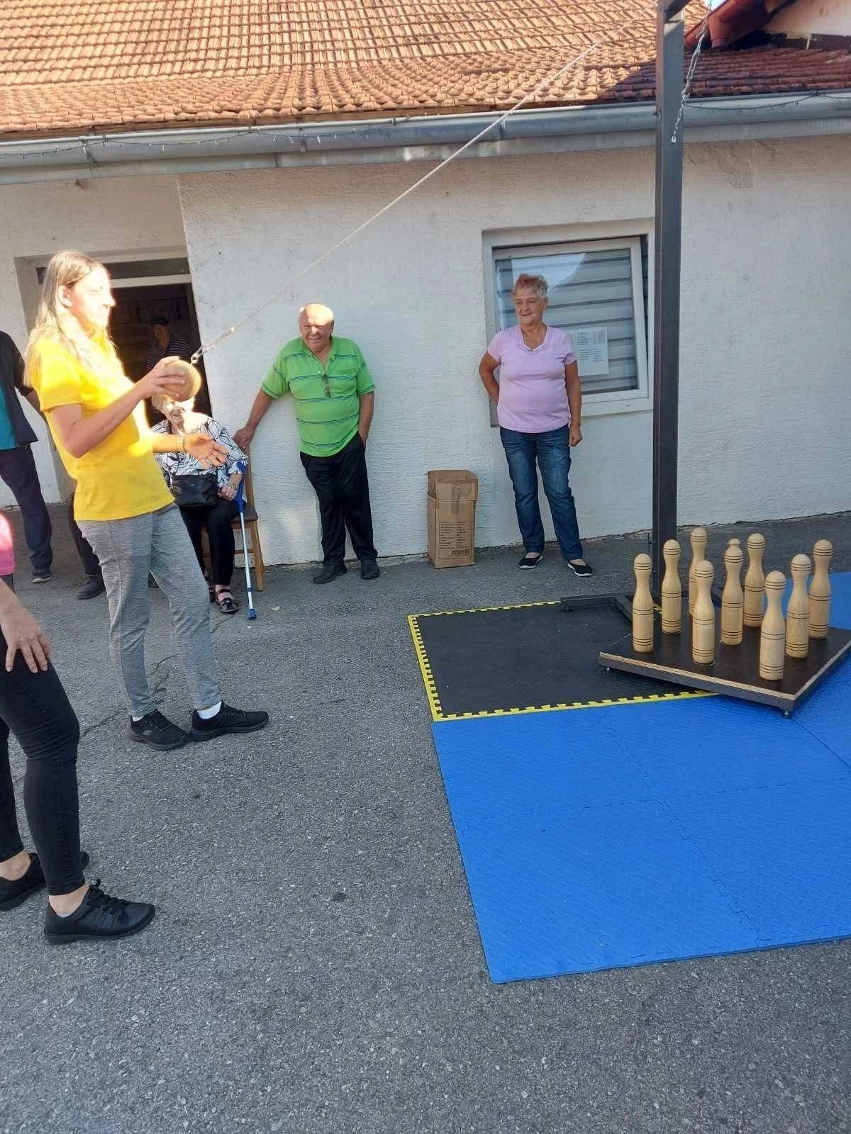 Sudionica igra viseću kuglanu na Križevačkoj parasportskoj ligi, uz druge natjecatelje.