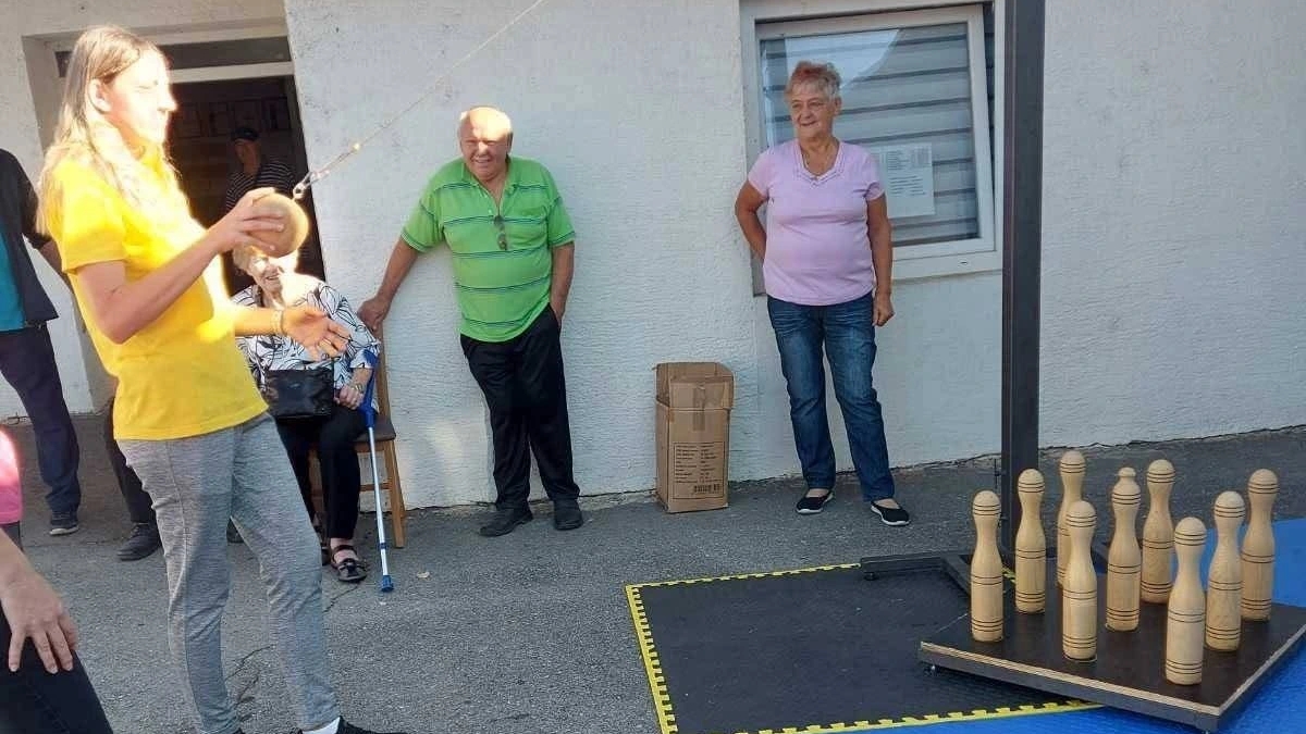 Sudionica igra viseću kuglanu na Križevačkoj parasportskoj ligi, uz druge natjecatelje.
