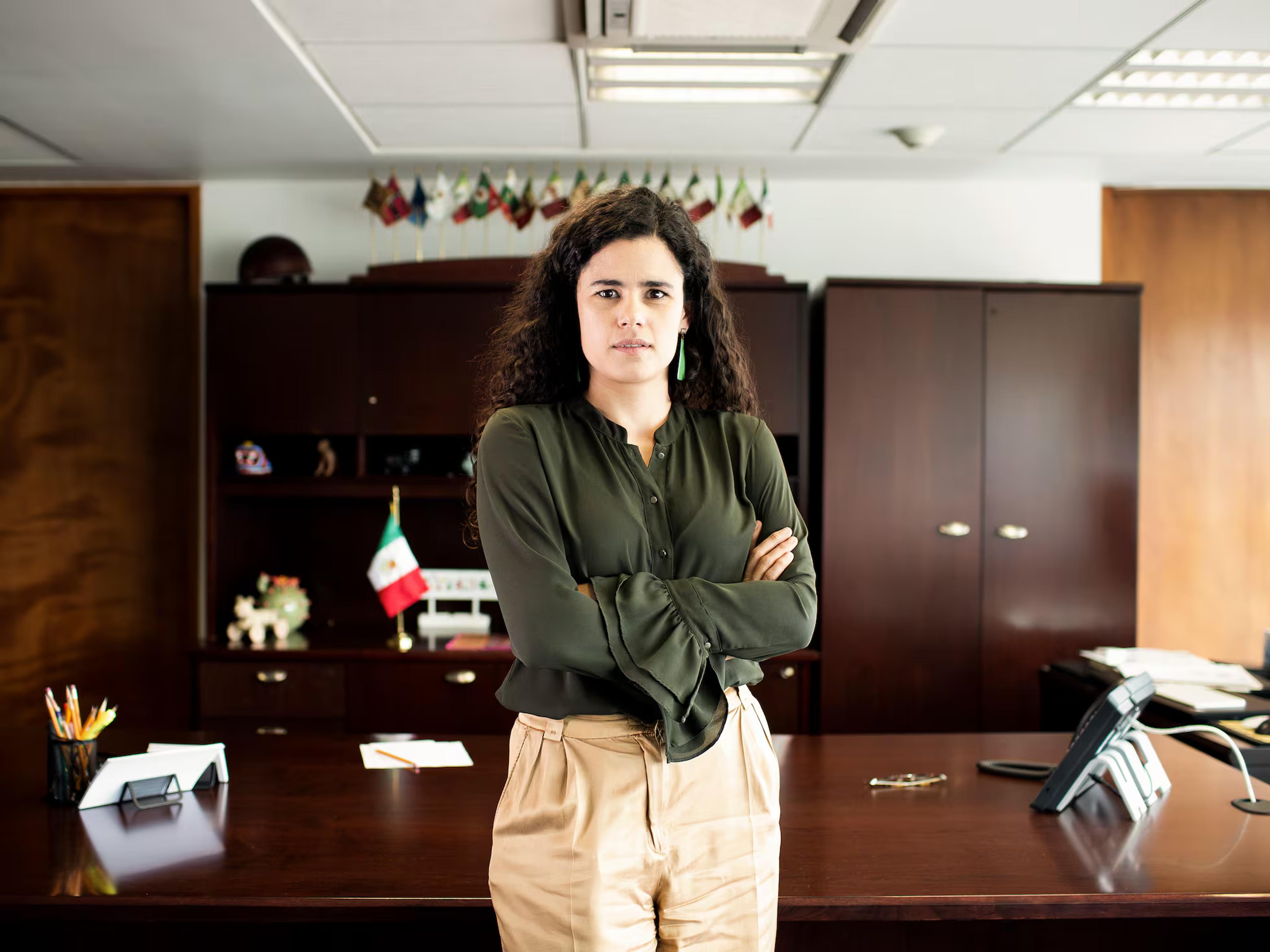A woman standing in an office with her arms crossed
