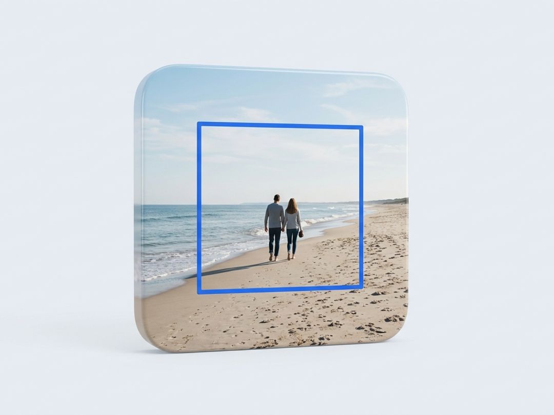 A photograph of two people walking on a beach, with a blue square outline marking the smaller region a crop would keep.