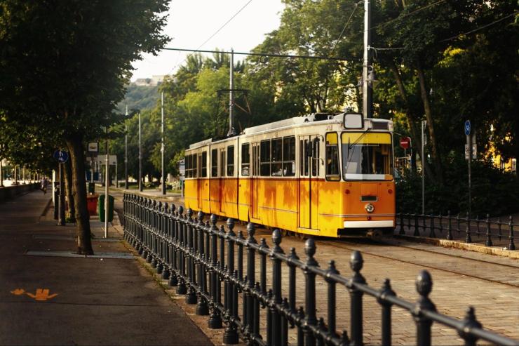 A yellow tram on a city street. 