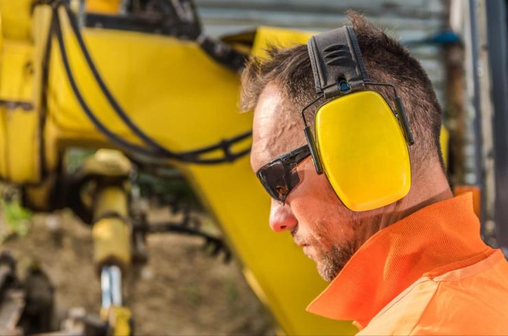 Construction Worker Wearing Sunglasses and Noise Cancelling Earmuffs.