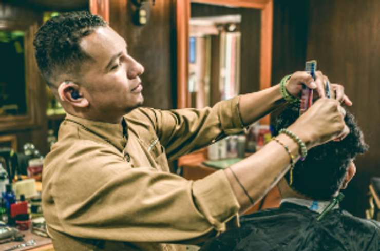 A man with hearing aid as a hairdresser.