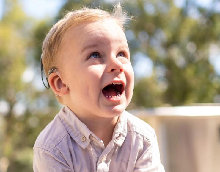 Toddler wearing a hearing aid.