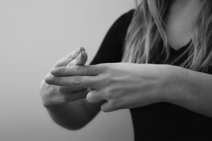 Black and white photo of woman signing the word ‘name.