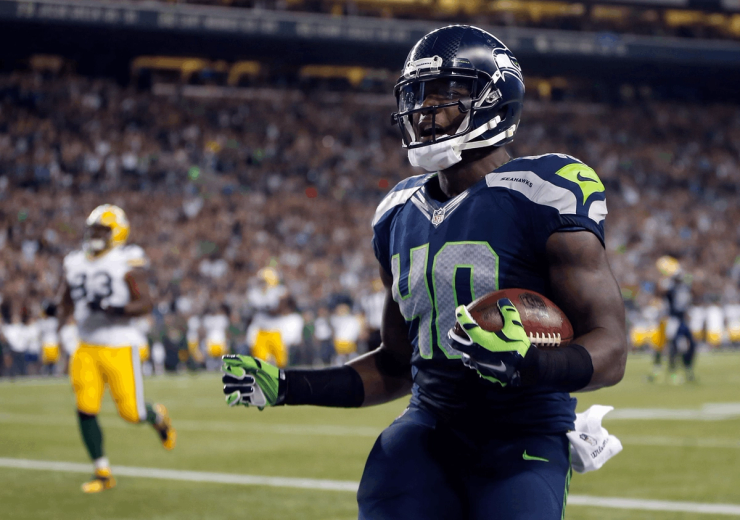 Derrick Coleman playing for the Seattle Seahawks, deaf NFL player running with the football during a game