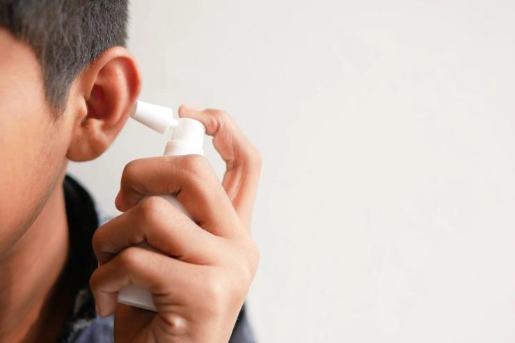 Man using a cleaning solution to clean ears