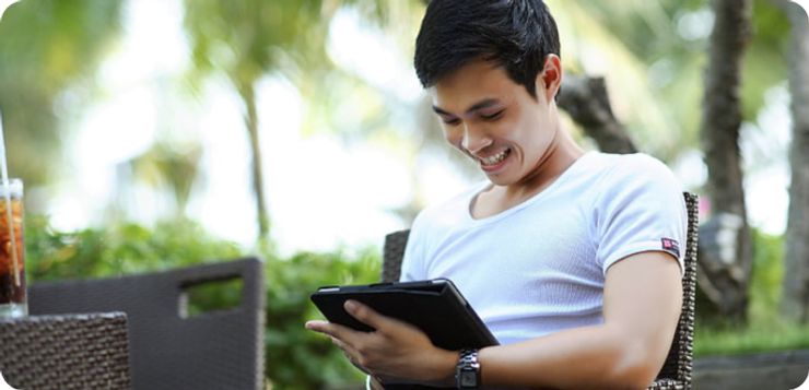 Smiling man watching at tablet.
