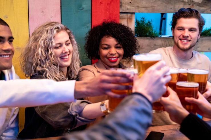 Friends drinking and toasting beer mugs.