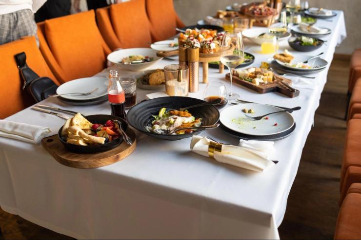 A Thanksgiving dinner is set up on a formal dinner table.