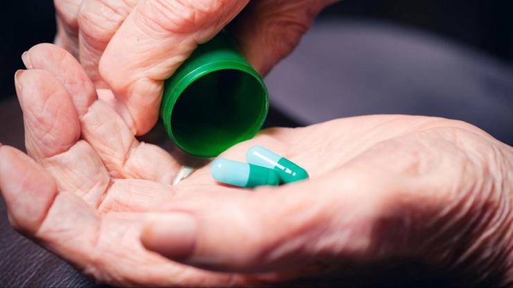 Close-up of medication capsules in hand, highlighting potential risks of ototoxic drugs that may contribute to hearing loss