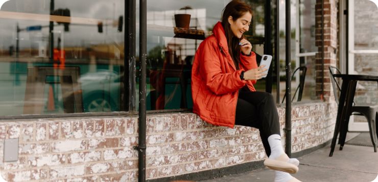 Smiling girl is watching at mobile phone.
