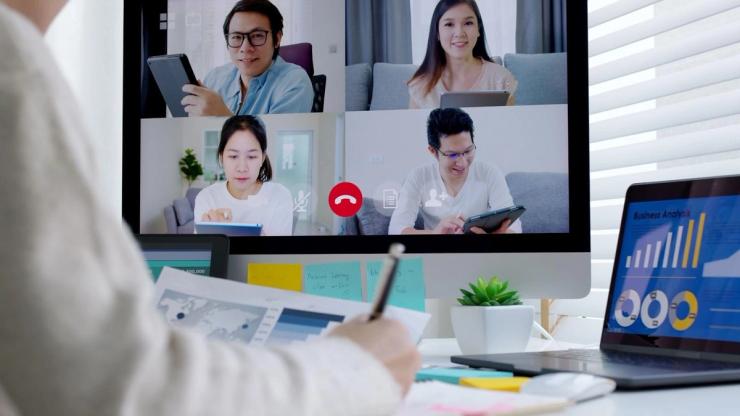 A person taking notes during a video conference call