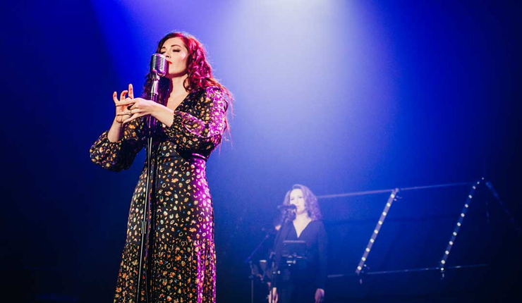 Mandy Harvey performing on stage, deaf singer and songwriter known for using visual cues and vibration to perform music