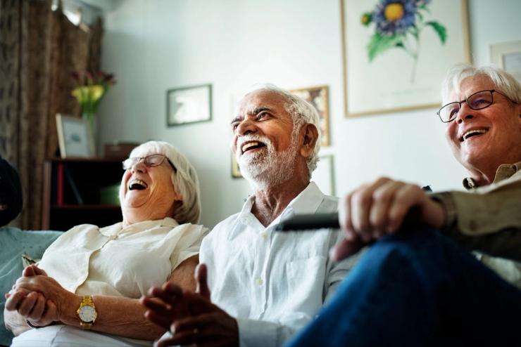 A group of three Senior individuals watching TV