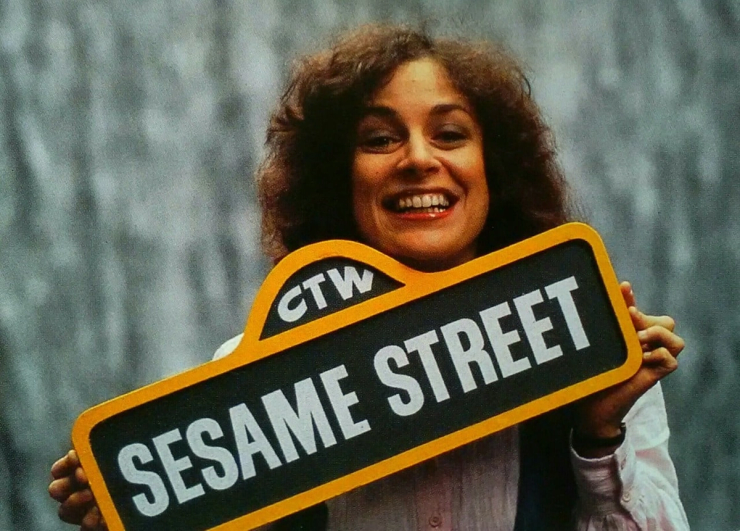 Linda Bove holding a Sesame Street sign, deaf actress known for her role on Sesame Street and advocacy for deaf representation