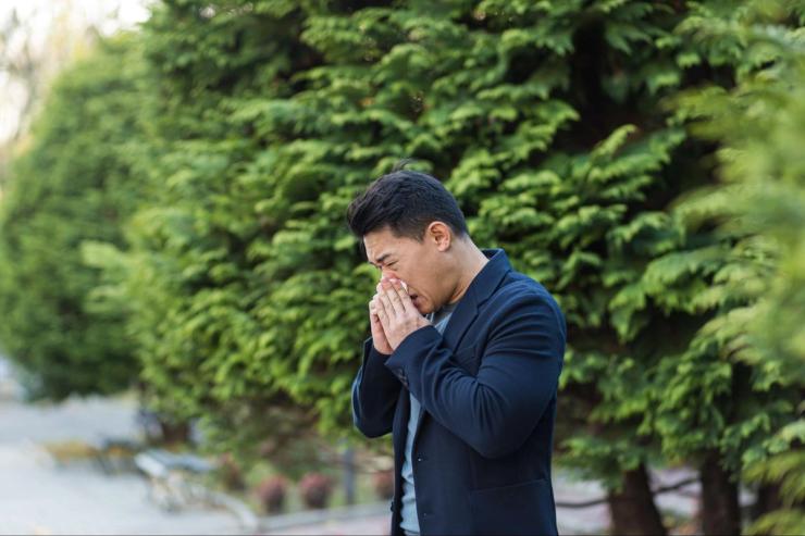 Man sneezing outdoors
