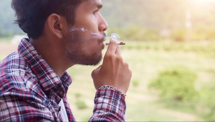 Man smoking outdoors as an example of lifestyle habits that can impact hearing health and increase hearing loss risk