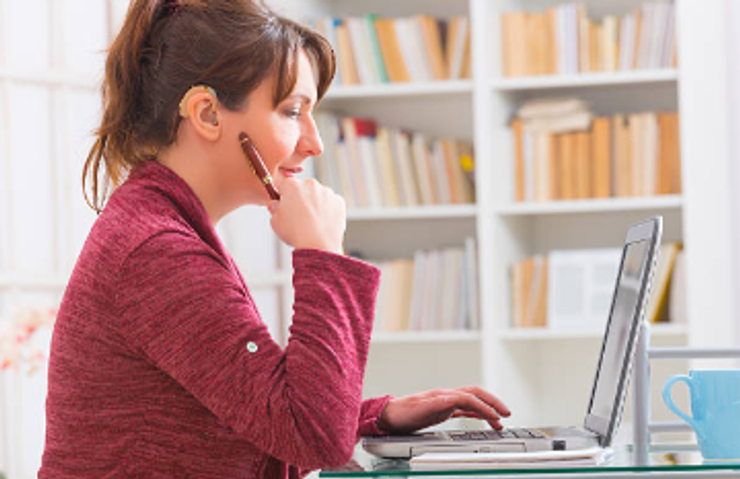 A woman with hearing aid on a  meeting.