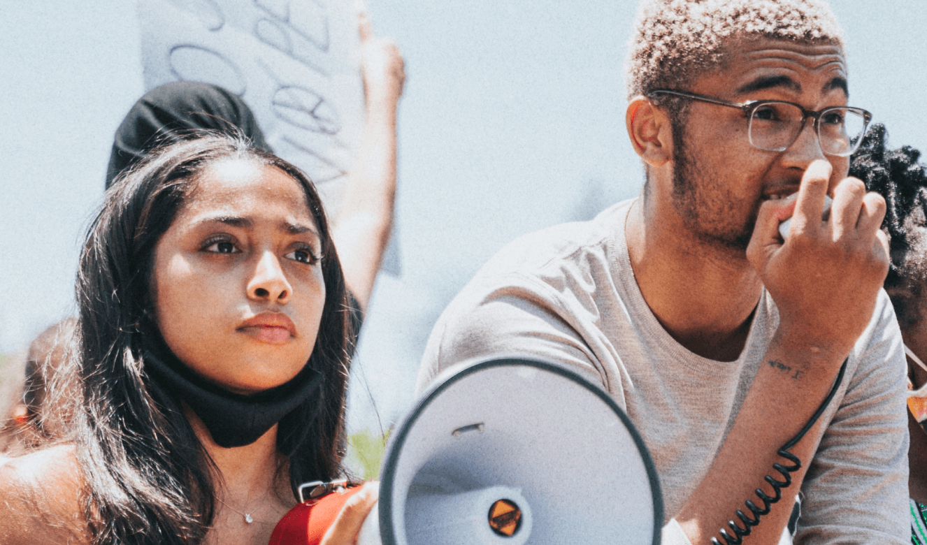 Two young activists with a megaphone partake in peaceful protest